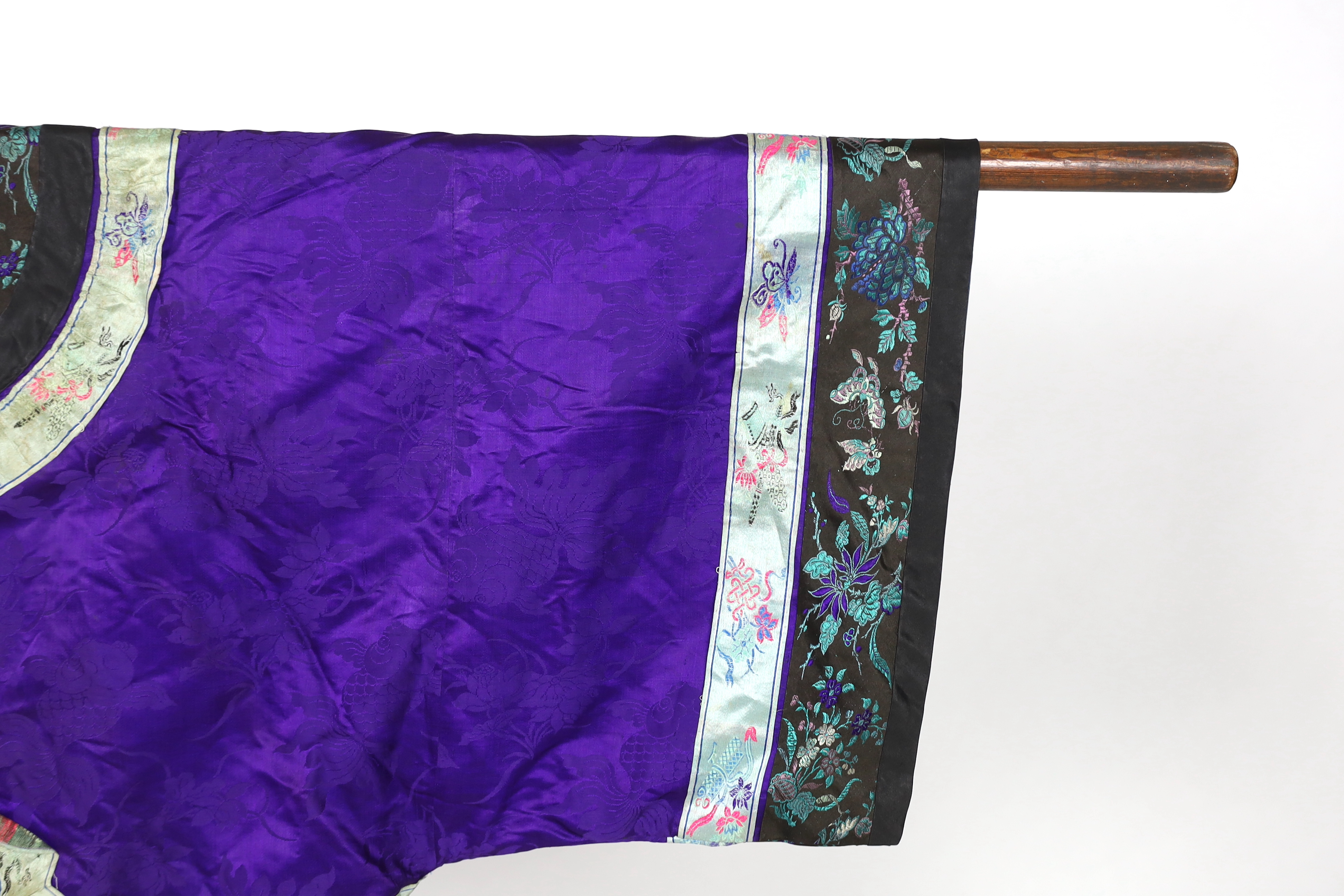 A Chinese purple damask jacket, circa late 19th / early 20th century, decorated with black and turquoise embroidered braiding with auspicious symbols, butterflies and flowers embroidery, 63cm long